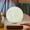 Hand reaching toward floating Lunara Moon Lamp